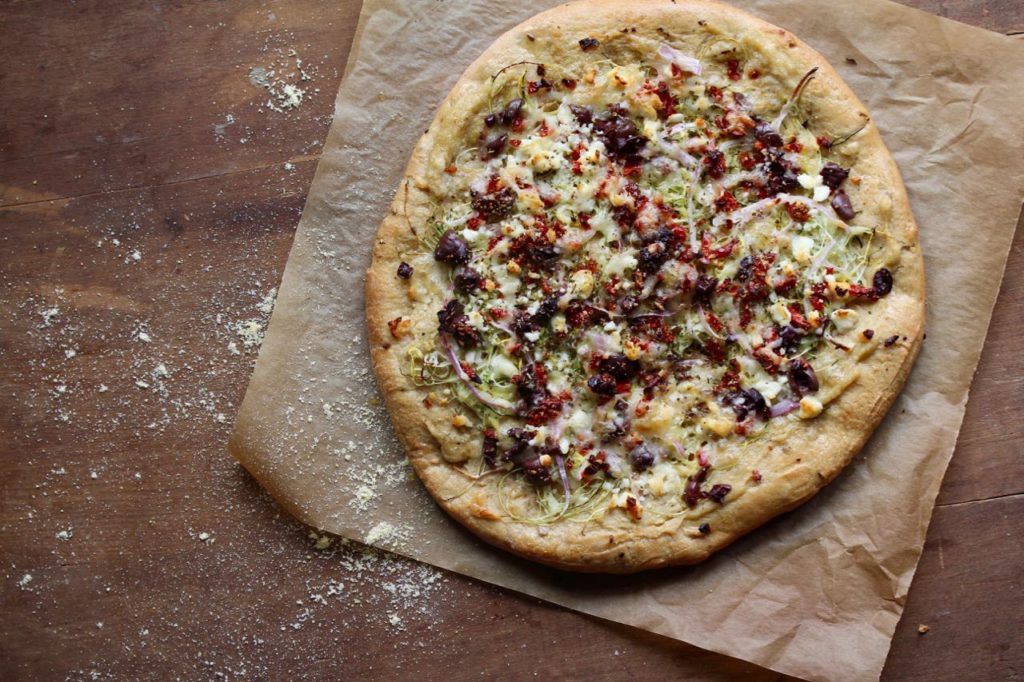 Looking for a fun, new way to enjoy pizza? Try this Mediterranean Pizza which starts with a layer of hummus and gets topped with tons of fresh veggies, feta cheese and olives! @cookinRD | sarahaasrdn.com